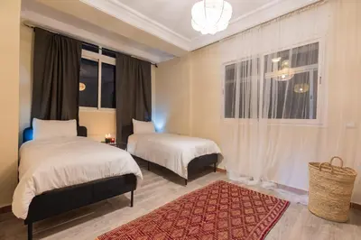 a bedroom with two beds and a window at Stylish APPT 2 BDR Downtown of Rabat by MERAT HOME in Rabat