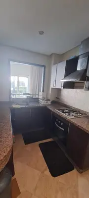 a kitchen with black cabinets and a counter top at Appartement Beach House 2 Dar Bouazza in Dar Bouazza