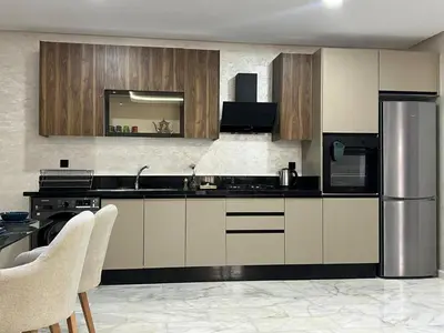 a kitchen with wooden cabinets and a stainless steel refrigerator at M océan in Mohammedia