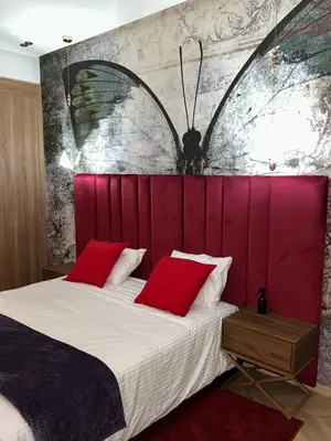 a bedroom with a large bed with a red headboard at Studio chaleureux 50m2 avec cuisine au centre de casa et proche du tramway ghandi in Casablanca