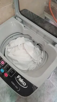a small bed in a washing machine with a remote control at appartement pour les familles , couples mariés bien meublé à Rabat in Rabat