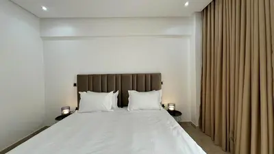 a bedroom with a large bed with white sheets and pillows at Maarif 6TH Floor with 3 Bedrooms - AppartAli in Casablanca
