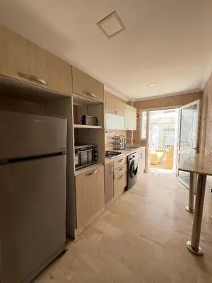 a kitchen with a refrigerator and a stove top oven at SUITOUISS - Agdal 4 - Appartements à 2 minutes de la gare de train TGV Rabat in Rabat