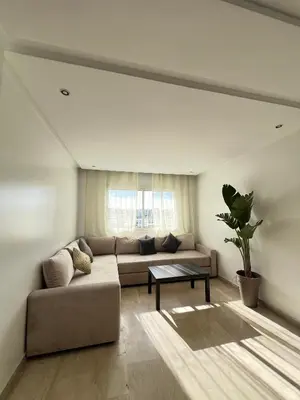 a living room with a couch and a table at SUITOUISS - Agdal 4 - Appartements à 2 minutes de la gare de train TGV Rabat in Rabat