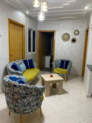 a living room with two chairs and a couch and a table at Airport house hotel in Derroua