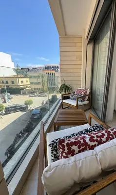 a balcony with a bed and a view of a street at Sublime Résidence - Dreamy Appartment 1BR in Maarif