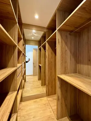 a walk in closet with wooden shelves at Sublime Résidence - Dreamy Appartment 1BR in Maarif