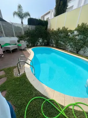 a swimming pool in front of a building at villa azur in Dar Bouazza