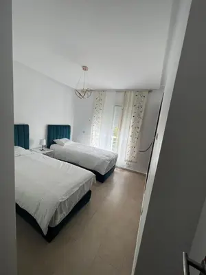 a bedroom with two beds and a window at villa azur in Dar Bouazza