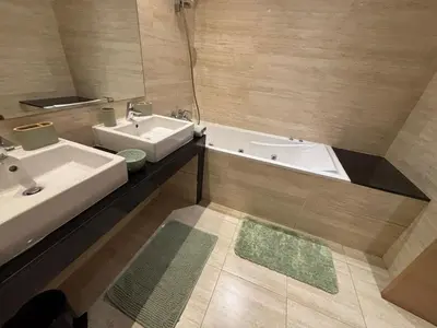a bathroom with two sinks and a bath tub at Bouskoura, appart jardin privé in Casablanca