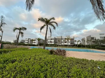 a resort with a swimming pool and palm trees at Bouskoura, appart jardin privé in Casablanca