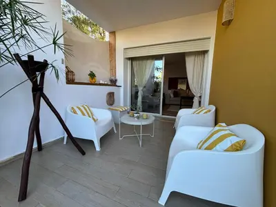 a living room with two white couches and a table at Bouskoura, appart jardin privé in Casablanca