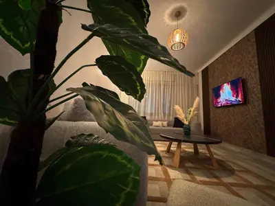 a living room with a large plant and a table at Appartement de luxe 155m agdal centre in Rabat