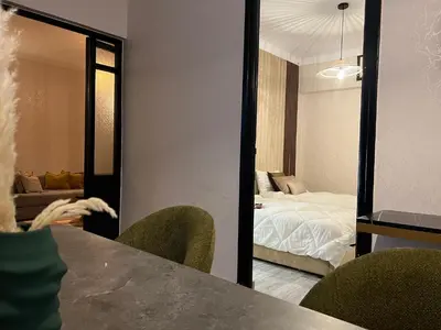 a room with a bedroom with a bed and a mirror at Appartement de luxe 155m agdal centre in Rabat