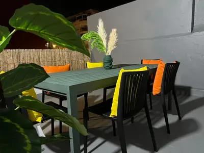a green dining room table with chairs and a plant at Appartement de luxe 155m agdal centre in Rabat