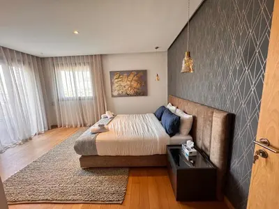 a bedroom with a bed and a couch at Duplex de luxe avec jardin au coeur de la marina in Casablanca