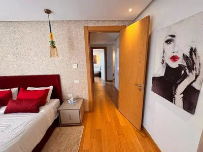 a room with a bed and a painting on the wall at Duplex de luxe avec jardin au coeur de la marina in Casablanca
