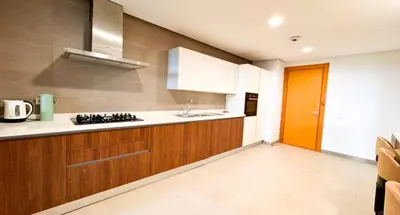 a kitchen with wooden cabinets and a orange door at Duplex de luxe avec jardin au coeur de la marina in Casablanca