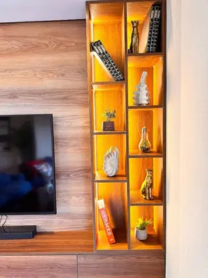 a wooden book shelf with a tv in a room at Duplex de luxe avec jardin au coeur de la marina in Casablanca