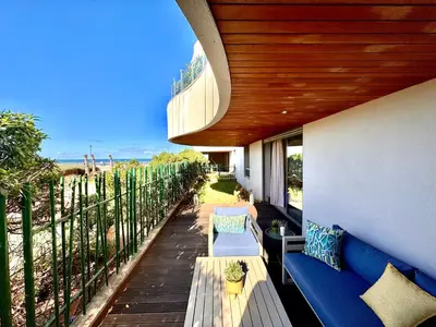 a porch with a blue bench and a fence at Duplex de luxe avec jardin au coeur de la marina in Casablanca