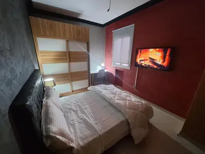 a bedroom with a bed and a tv on the wall at charmant appart à Mohammedia in Mohammedia