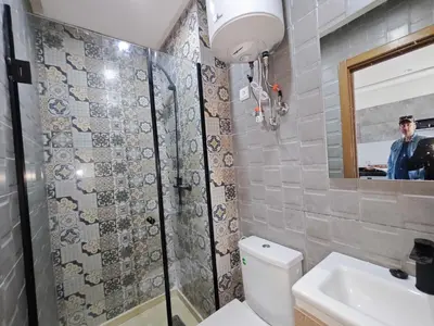 a bathroom with a toilet and a sink and a mirror at Anchor point in Dar Bouazza