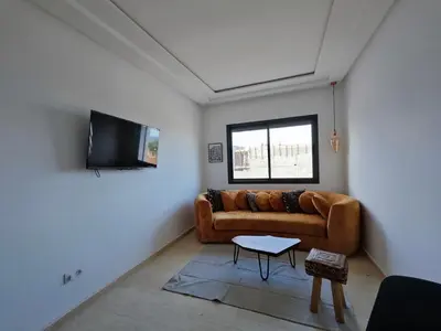 a living room with a couch and a tv at Anchor point in Dar Bouazza
