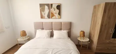 a bedroom with a white bed with two side tables at One-Five Racine by IB Signature, Stylish 2BR Apt, 24x7 Security, WiFi, Self check-in, City View, City Centre, close to cafes and restaurants in Casablanca