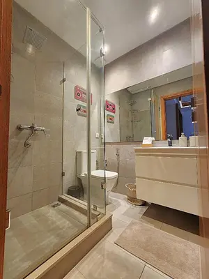a bathroom with a shower and a toilet and a sink at One-Five Racine by IB Signature, Stylish 2BR Apt, 24x7 Security, WiFi, Self check-in, City View, City Centre, close to cafes and restaurants in Casablanca