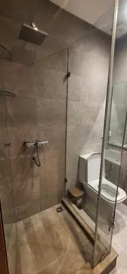 a bathroom with a shower and a toilet at One-Five Racine by IB Signature, Stylish 2BR Apt, 24x7 Security, WiFi, Self check-in, City View, City Centre, close to cafes and restaurants in Casablanca