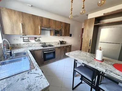 a kitchen with wooden cabinets and a counter top at One-Five Racine by IB Signature, Stylish 2BR Apt, 24x7 Security, WiFi, Self check-in, City View, City Centre, close to cafes and restaurants in Casablanca