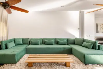 a living room with a green couch and a coffee table at Villa Luxueuse 4 Chambres au Cœur du Domaine a El Menzeh in El Menzeh