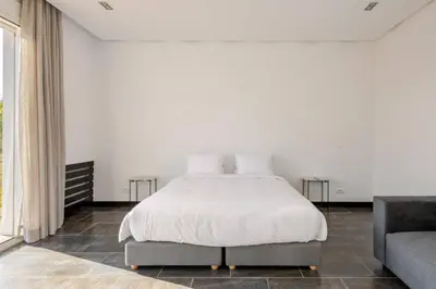 a white bedroom with a bed and a couch at Villa Luxueuse 4 Chambres au Cœur du Domaine a El Menzeh in El Menzeh