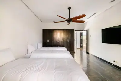 a bedroom with two beds and a ceiling fan at Villa Luxueuse 4 Chambres au Cœur du Domaine a El Menzeh in El Menzeh