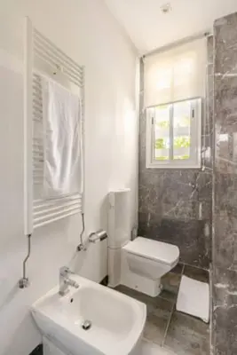 a white bathroom with a toilet and a sink at Villa Luxueuse 4 Chambres au Cœur du Domaine a El Menzeh in El Menzeh