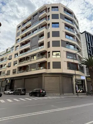 a large apartment building with cars parked in front of it at Studio luxueux à Maarif in Casablanca