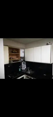 a small kitchen with white cabinets and a sink at Résidences Mansbay Jasmin in Mansouria