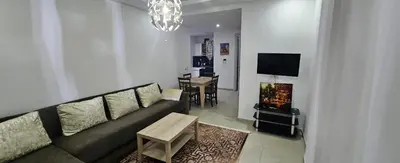 a living room with a couch and a table at Résidences Mansbay Jasmin in Mansouria