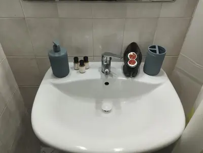 a bathroom sink with a faucet and cosmetics on it at Appartement au centre de Rabat Agdal in Rabat