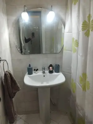 a bathroom with a white sink and a mirror at Appartement au centre de Rabat Agdal in Rabat