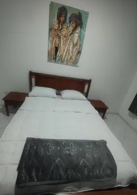 a bedroom with a bed with a painting on the wall at Appartement au centre de Rabat Agdal in Rabat