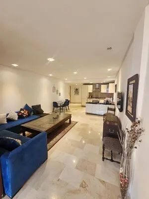 a living room with a blue couch and a kitchen at Studio spacieux plein centre in Casablanca