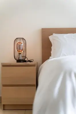 a bedroom with a bed and a nightstand with a lamp at Gauthier 5-Star Luxury Gem in Casablanca
