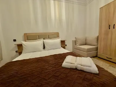 a bedroom with a large bed and a chair at Appartement exceptionnel en plein centre de rabat pour les familles et couples mariés in Rabat