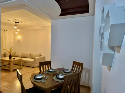 a dining room with a table and chairs and a couch at Appartement exceptionnel en plein centre de rabat pour les familles et couples mariés in Rabat