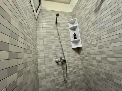 a shower with a hose attached to a tiled wall at Appartement exceptionnel en plein centre de rabat pour les familles et couples mariés in Rabat