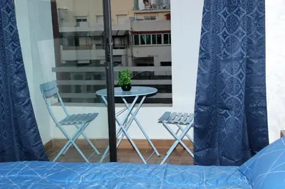 a table and chairs on a balcony with a potted plant at cosy studio au coeur de casablanca in Maarif