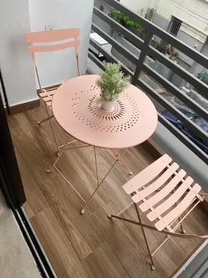a pink table and two chairs on a balcony at cosy studio au coeur de casablanca in Maarif