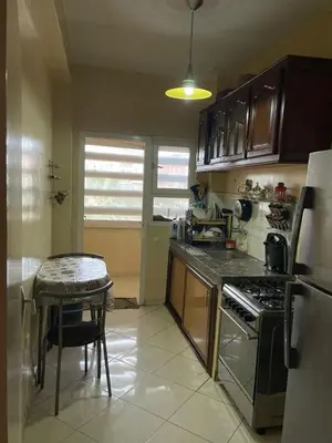 a kitchen with a stove and a table in it at Appartement à Ain Sebaa proche de tous les commodites in Casablanca
