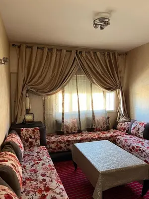 a living room with two beds and a window at Appartement à Ain Sebaa proche de tous les commodites in Casablanca